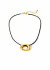Necklace with gold circular pendants on a black cord against a white background