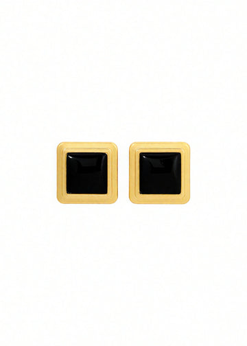 Pair of square-shaped earrings with black centers and gold borders on a white background