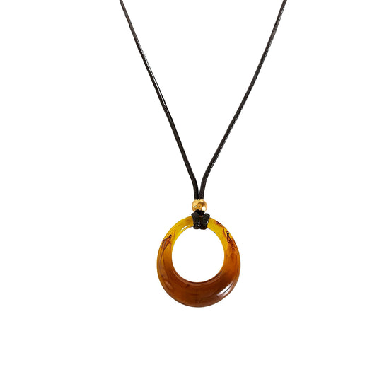 Amber circular pendant on a black cord against a white background