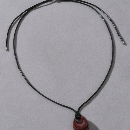 Necklace with a red pendant on a gray background