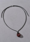 Necklace with a red pendant on a gray background