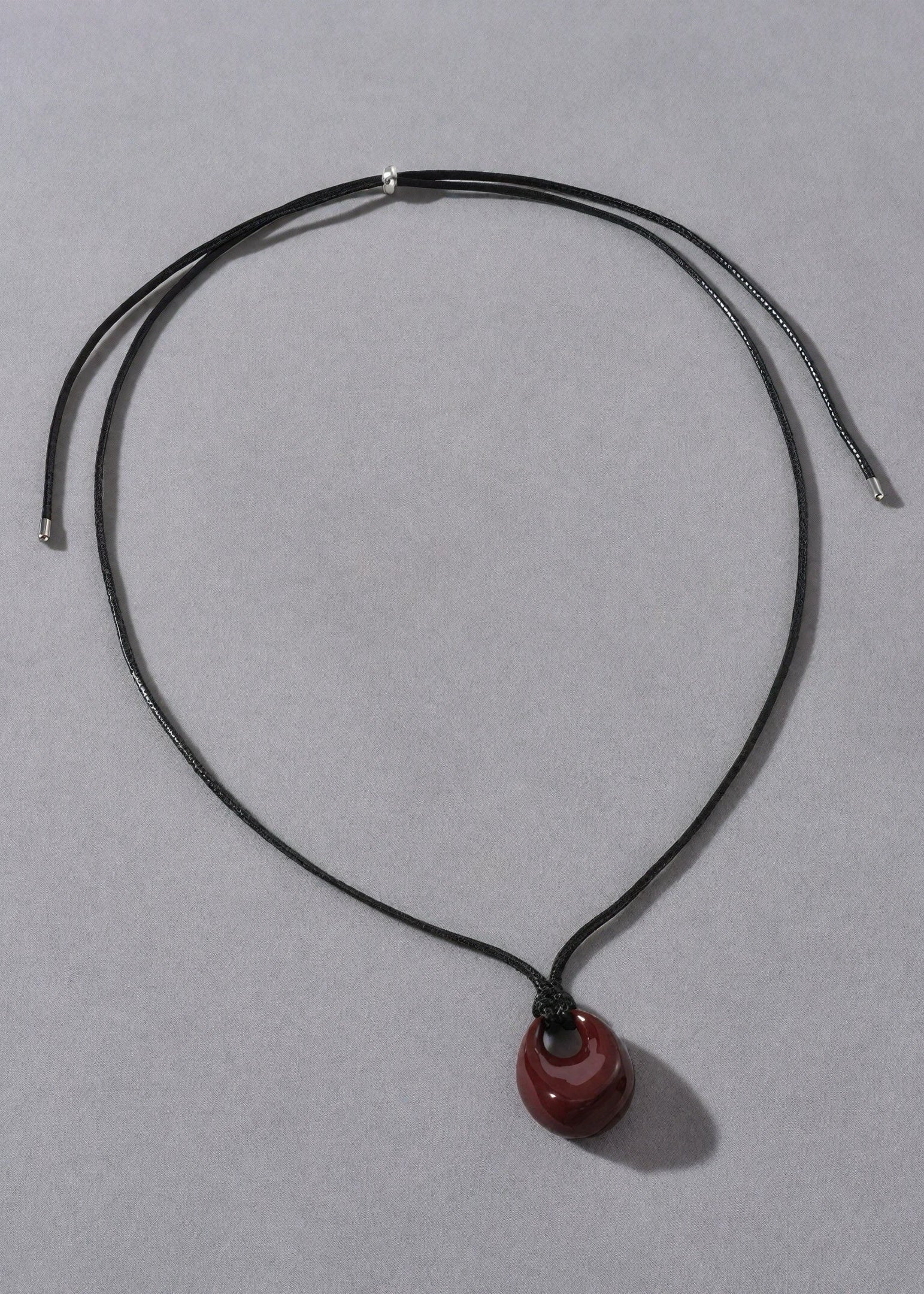 Necklace with a red pendant on a gray background