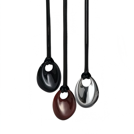 Three black pendant necklaces with different colored pendants on a white background