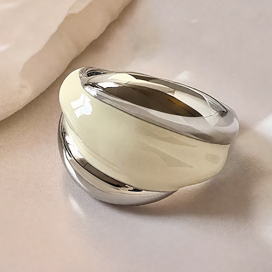 Silver cream white ring on a soft beige fabric background