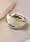 Silver cream white ring on a soft beige fabric background