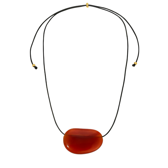 Black cord necklace with a large red agate pendant on a white background