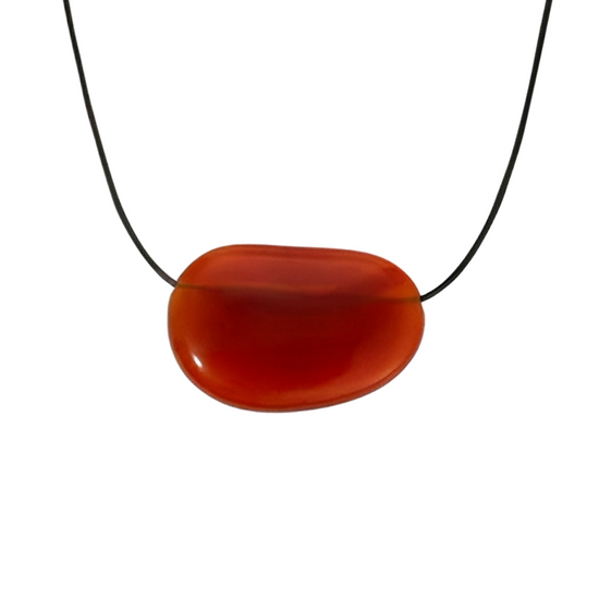 Black cord necklace with a large red agate pendant on a white background